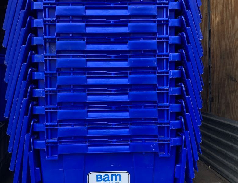 Blue plastic storage bins stacked together. 