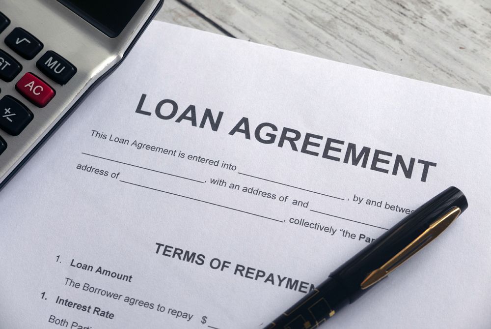 Loan agreement document with a pen and calculator.
