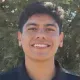 Smiling person in a black shirt outdoors with trees in the background
