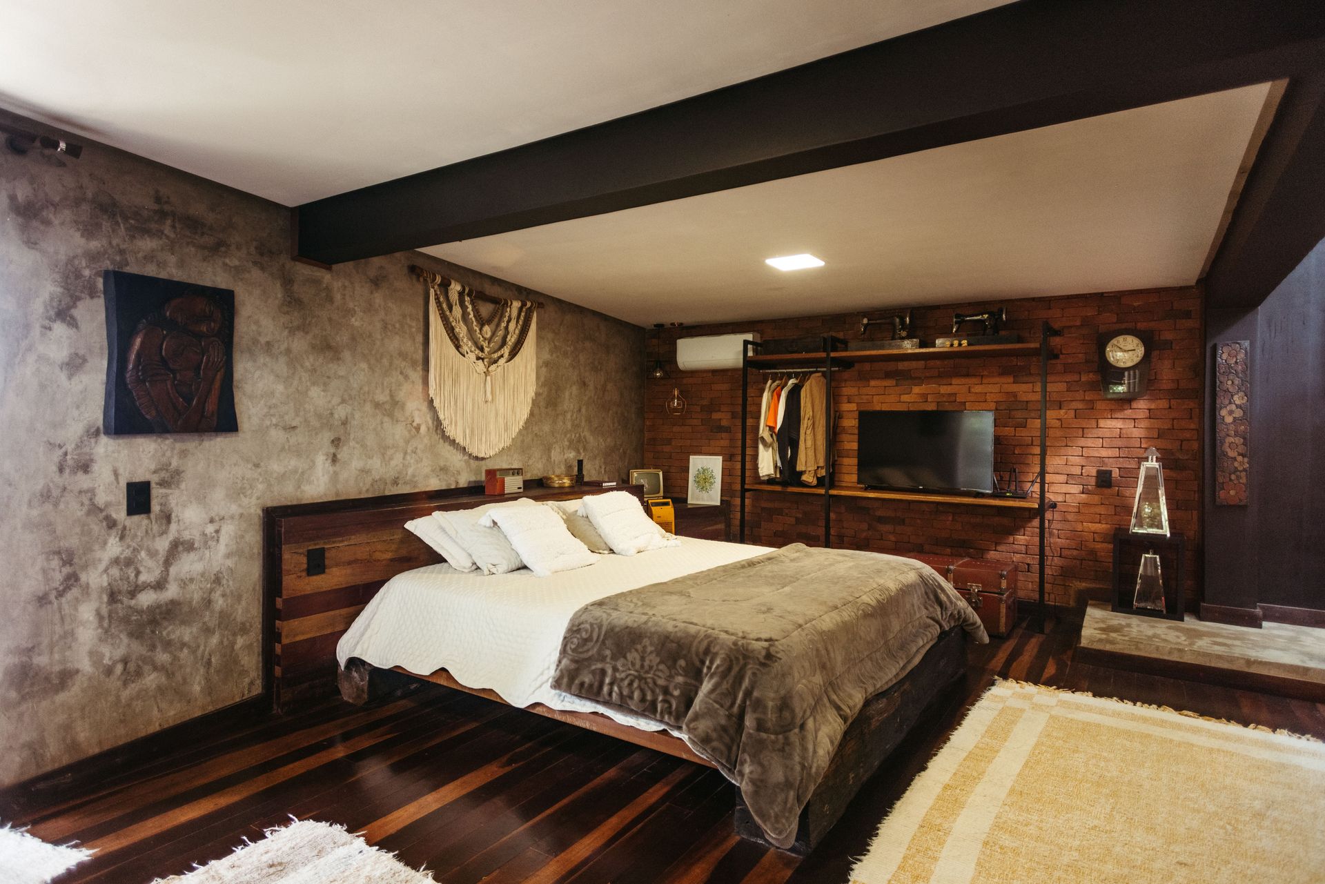 Cozy rustic bedroom with a large bed, wood accents, textured walls, and warm ambient lighting