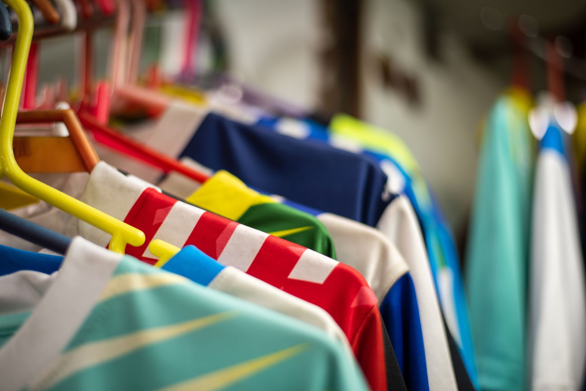 Colorful clothes on hangers in a closet or clothing rack