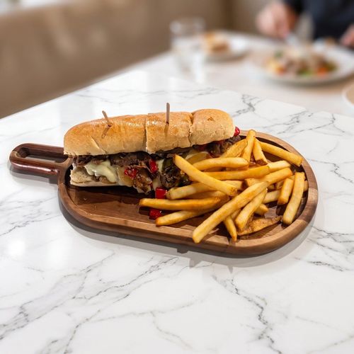 A mug of tan-colored coffee with small bubbles on top, set on a red surface.