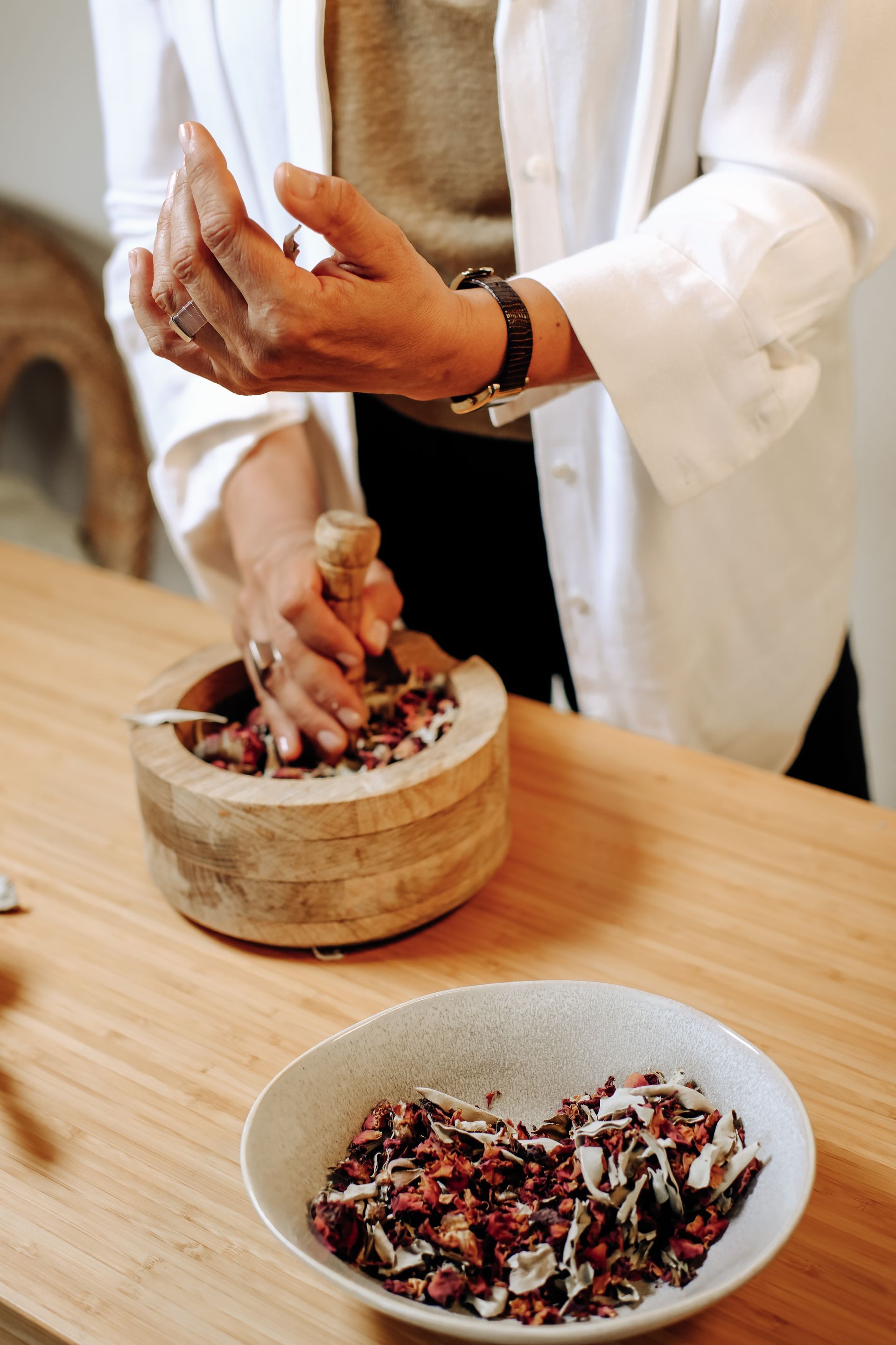 Person grinding ingredients with a pestle and mortar,