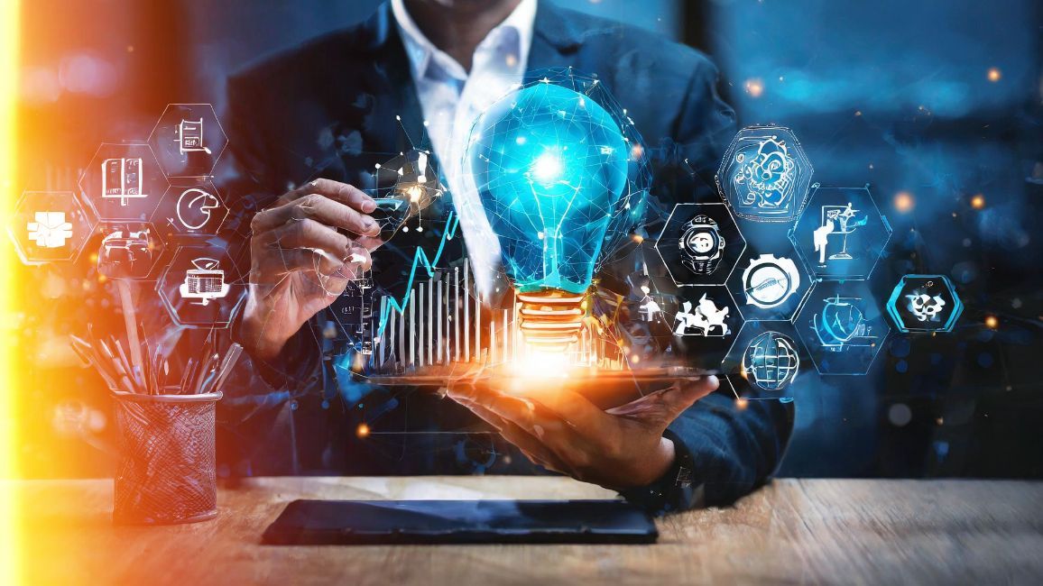 a man is holding a tablet with a light bulb coming out of it .
