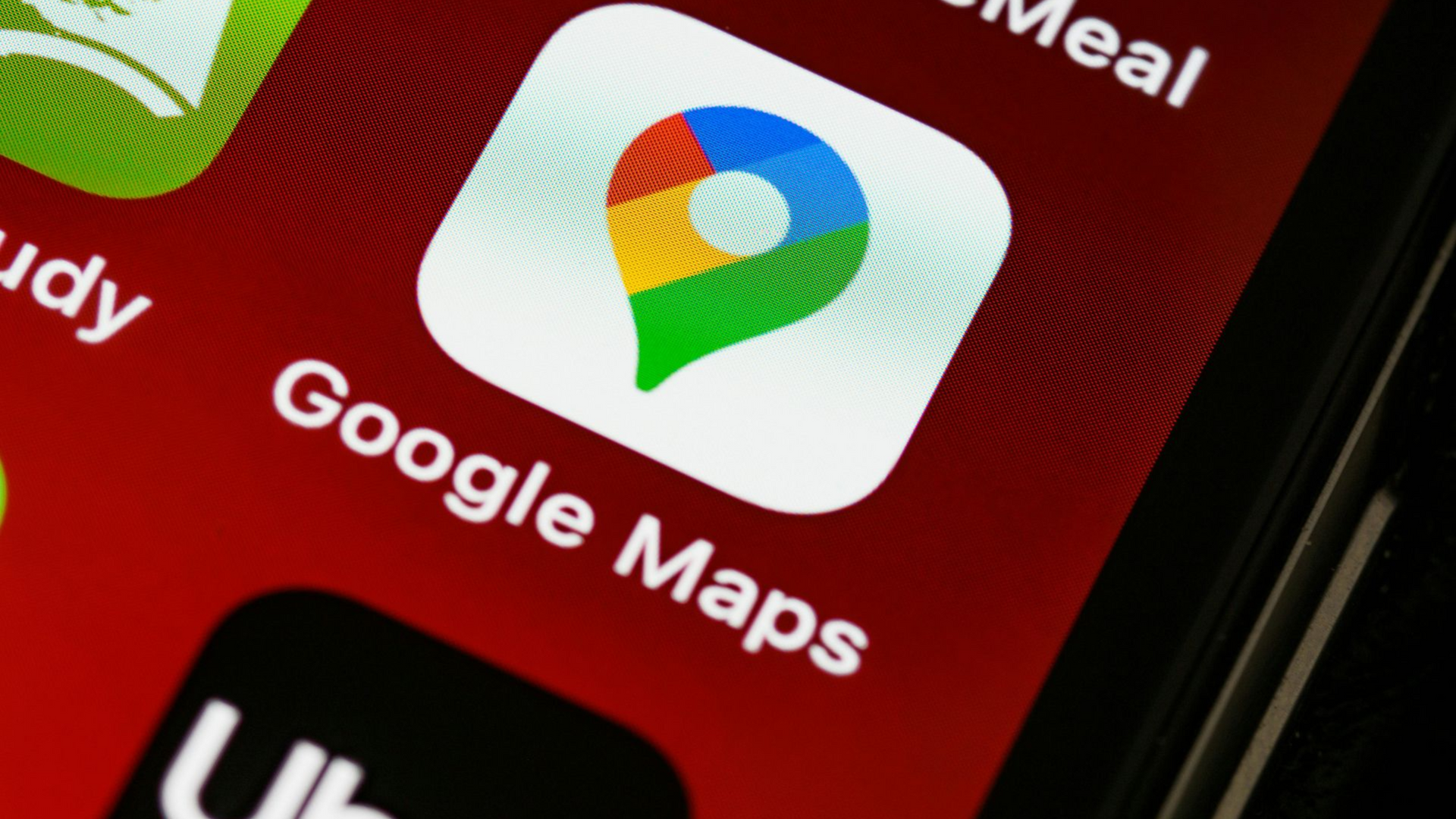 Google Maps app icon on a red phone screen.