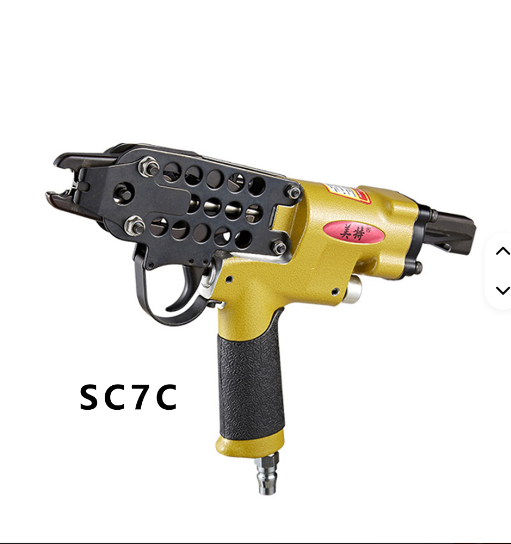 Pistola de clavos neumática amarilla y negra con placa frontal perforada, aislada sobre fondo blanco.