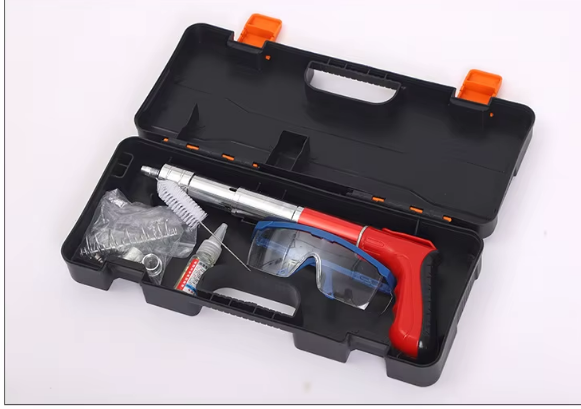 Maletín de herramientas negro abierto con pistola de calafateo roja, gafas de seguridad azules y accesorios