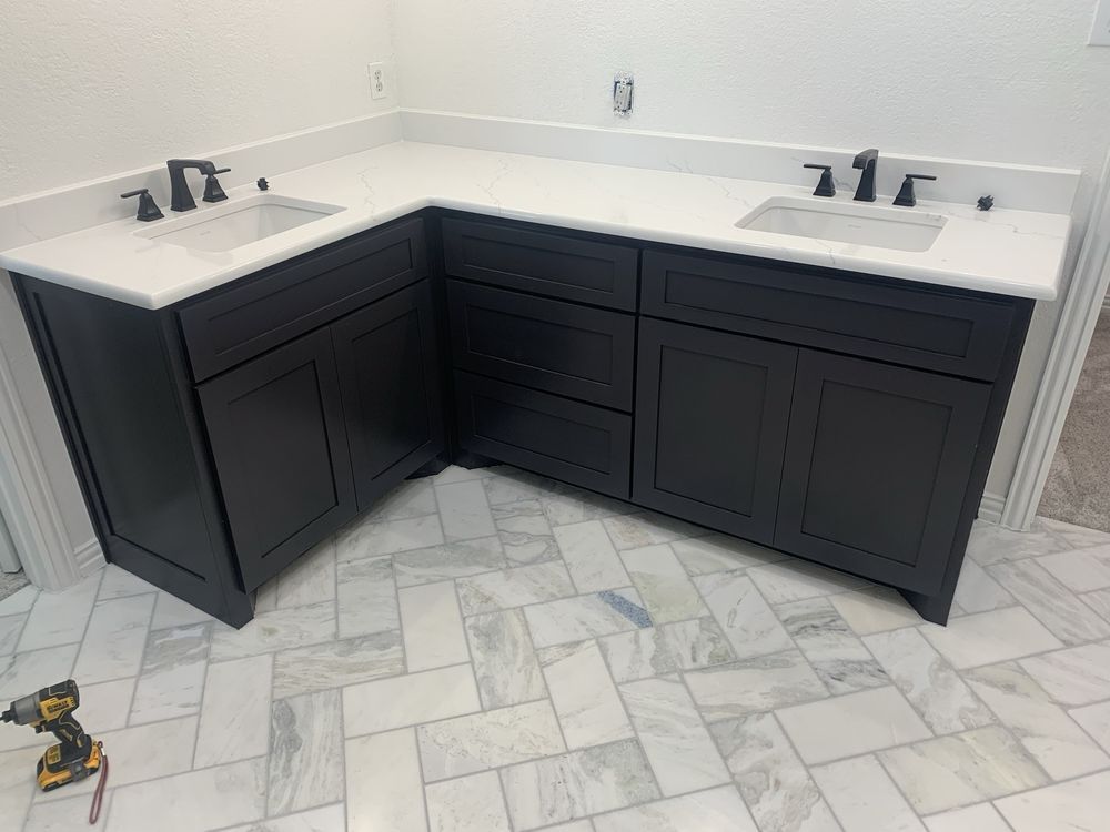 Double vanity bathroom with dark cabinets, white countertops, and marble-look tile floor.