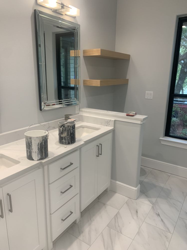 Bright modern bathroom with double vanity, large mirror, wall shelves, and marble-style floor tiles