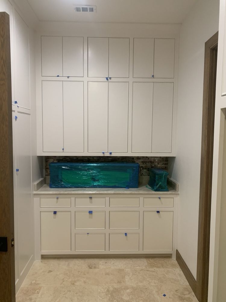 Narrow hallway with built-in white cabinets and a green-topped counter against the back wall.