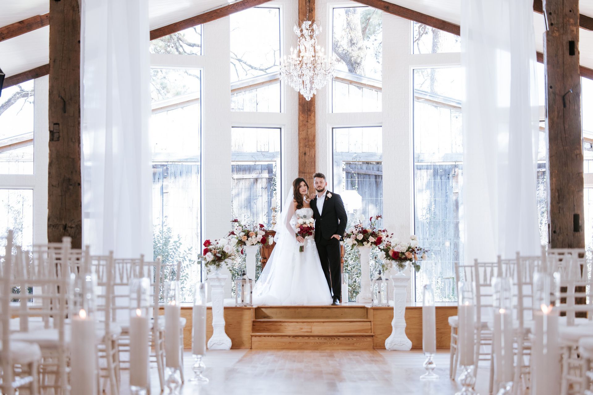 Bride and groom standing at the altar in a bright rustic wedding chapel