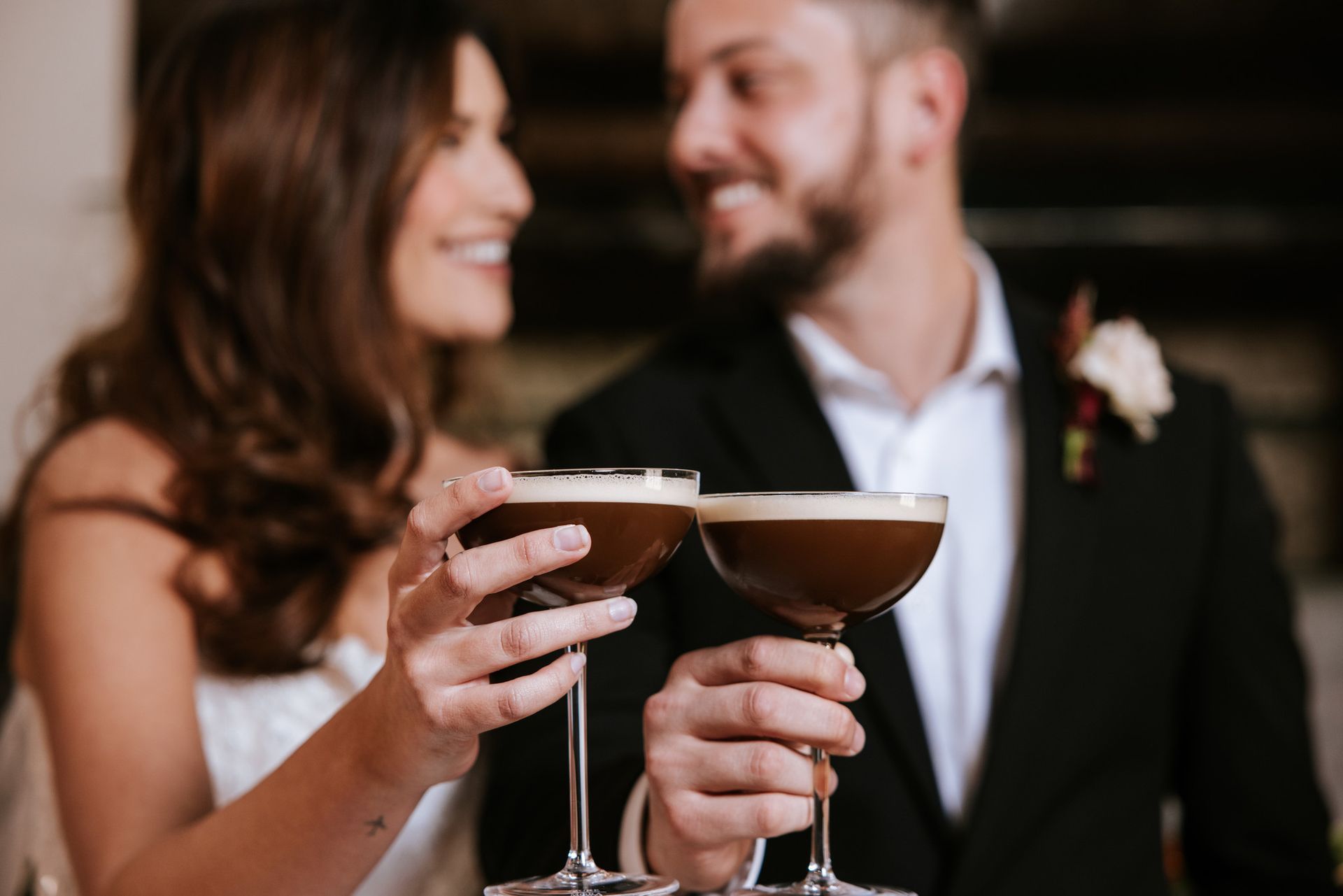 Two people in formal attire smiling and toasting champagne glasses at a celebration