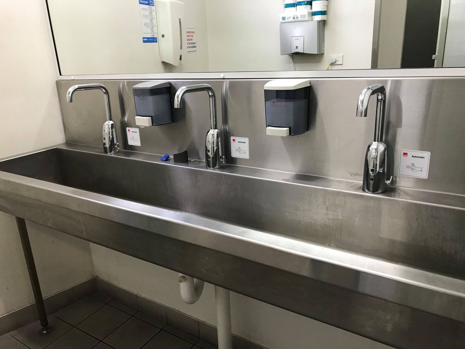Stainless steel sinks with three faucets and soap dispensers