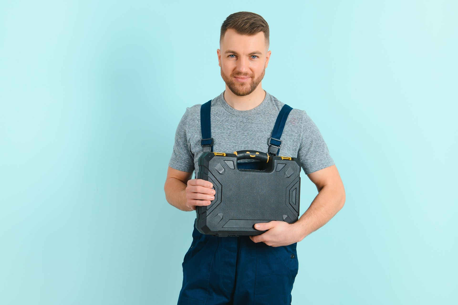 Portrait of smiling plumber in blue uniform isolated on blue background. Portrait of smiling plumber in blue uniform isolated on blue background.