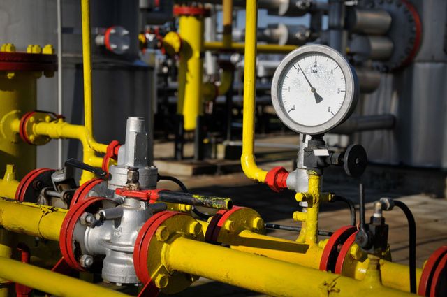 Tuberías industriales con conducciones de gas amarillas y un manómetro en una sala de máquinas