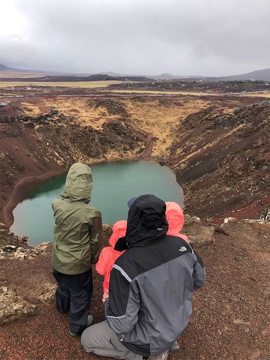 man and children are looking at a lake.