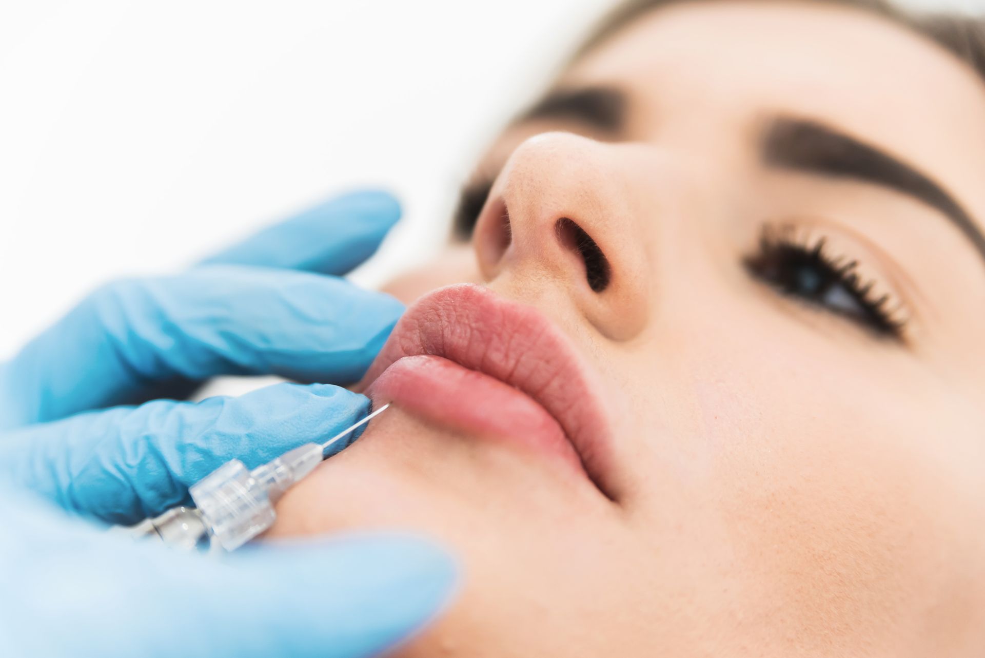A man receiving a Botox injection in a clinic from an aesthetician. A man receiving a Botox injection in a clinic from an aesthetician.