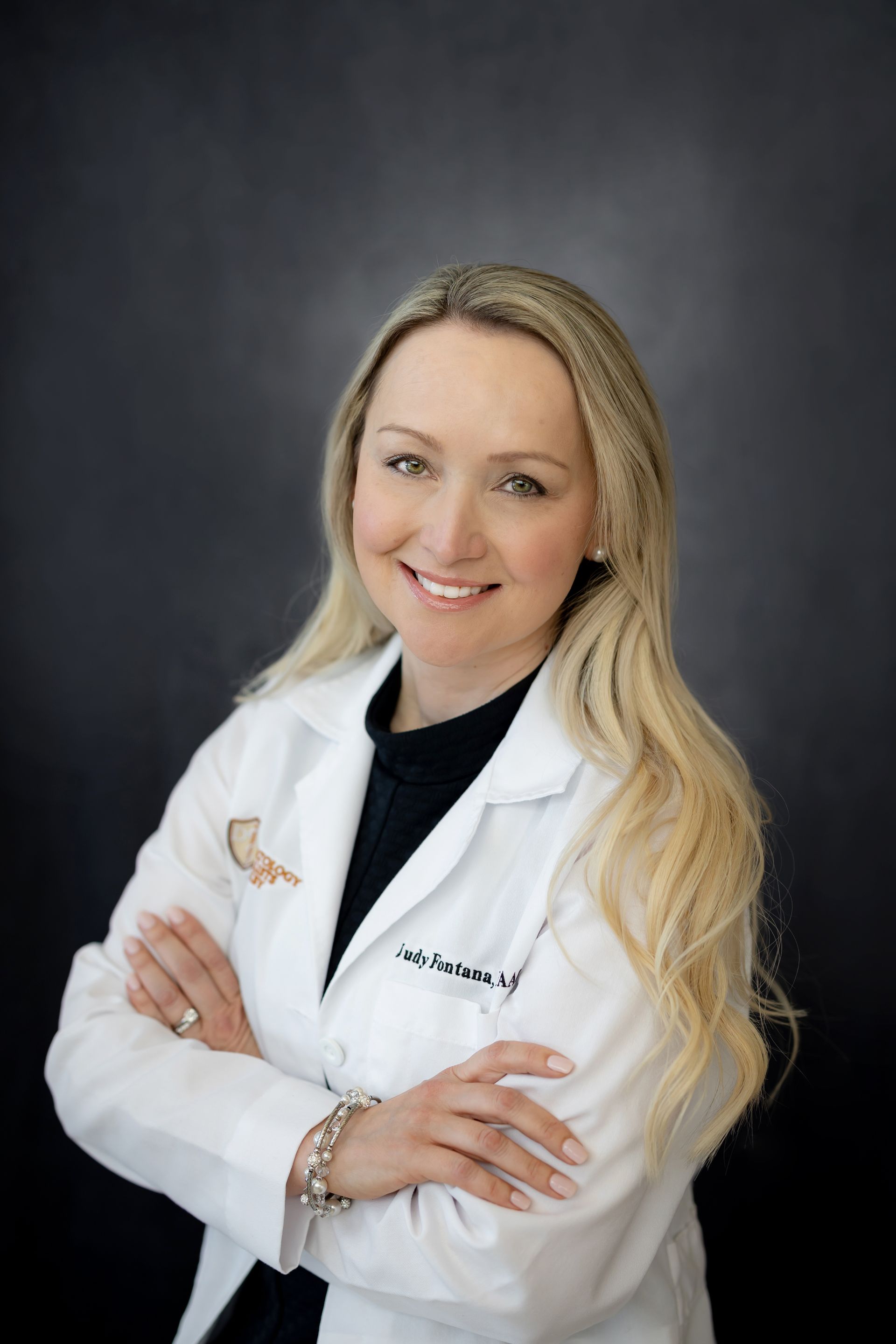 a woman in a white coat with judy fontana written on it | Local Specialists in Shelby Twp., MI | Hamzavi Dermatology