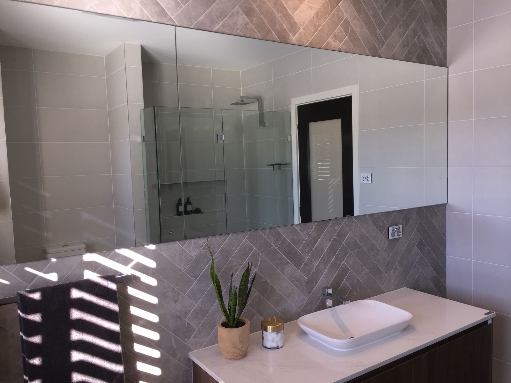 A Bathroom With A Sink, Toilet, And Large Mirror — Avoca Beach Glass In Lisarow, NSW