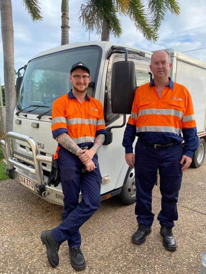 Two men are standing next to each other in front of a truck. — Mackay Hose Fitting Services In West Mackay, QLD