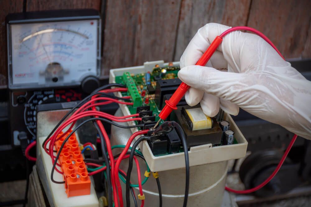 Man Using Analog Multimeter — Electrical Services in Uralla, NSW