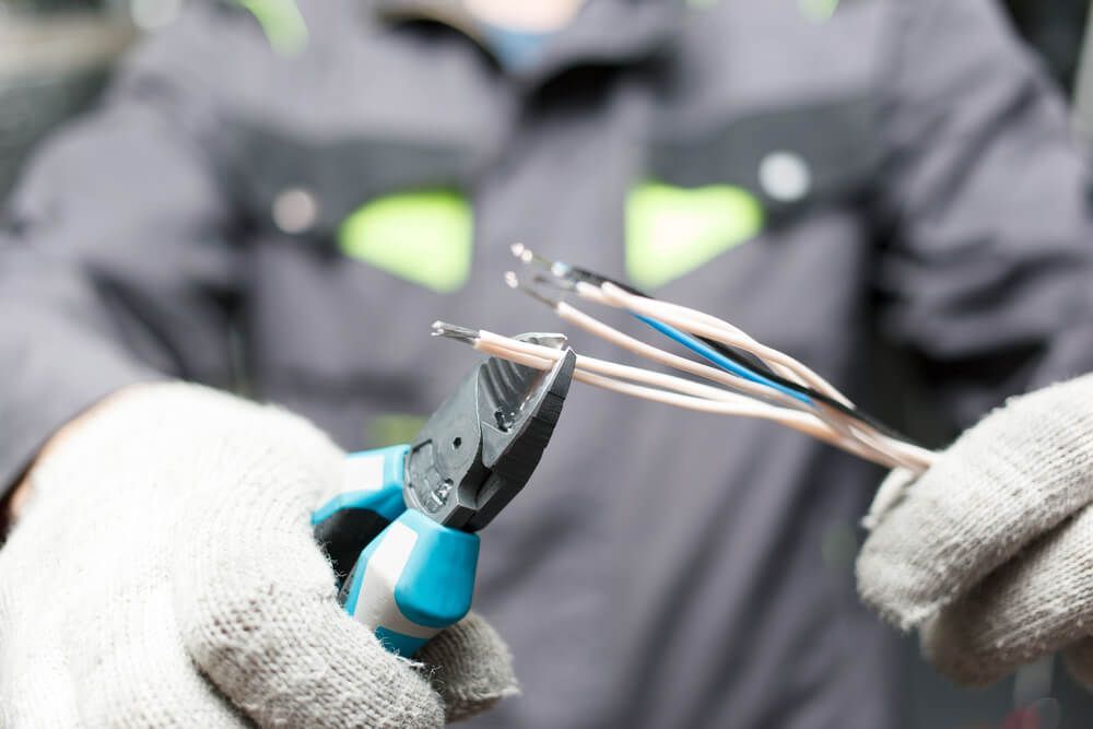 Electrician Stripping Wire Insulations — Electrical Services in Glen Innes, NSW