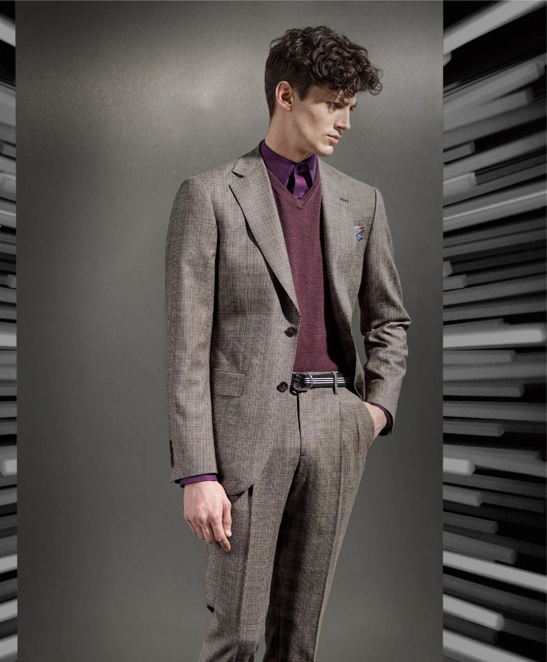 A man is wearing a suit and a purple shirt.
