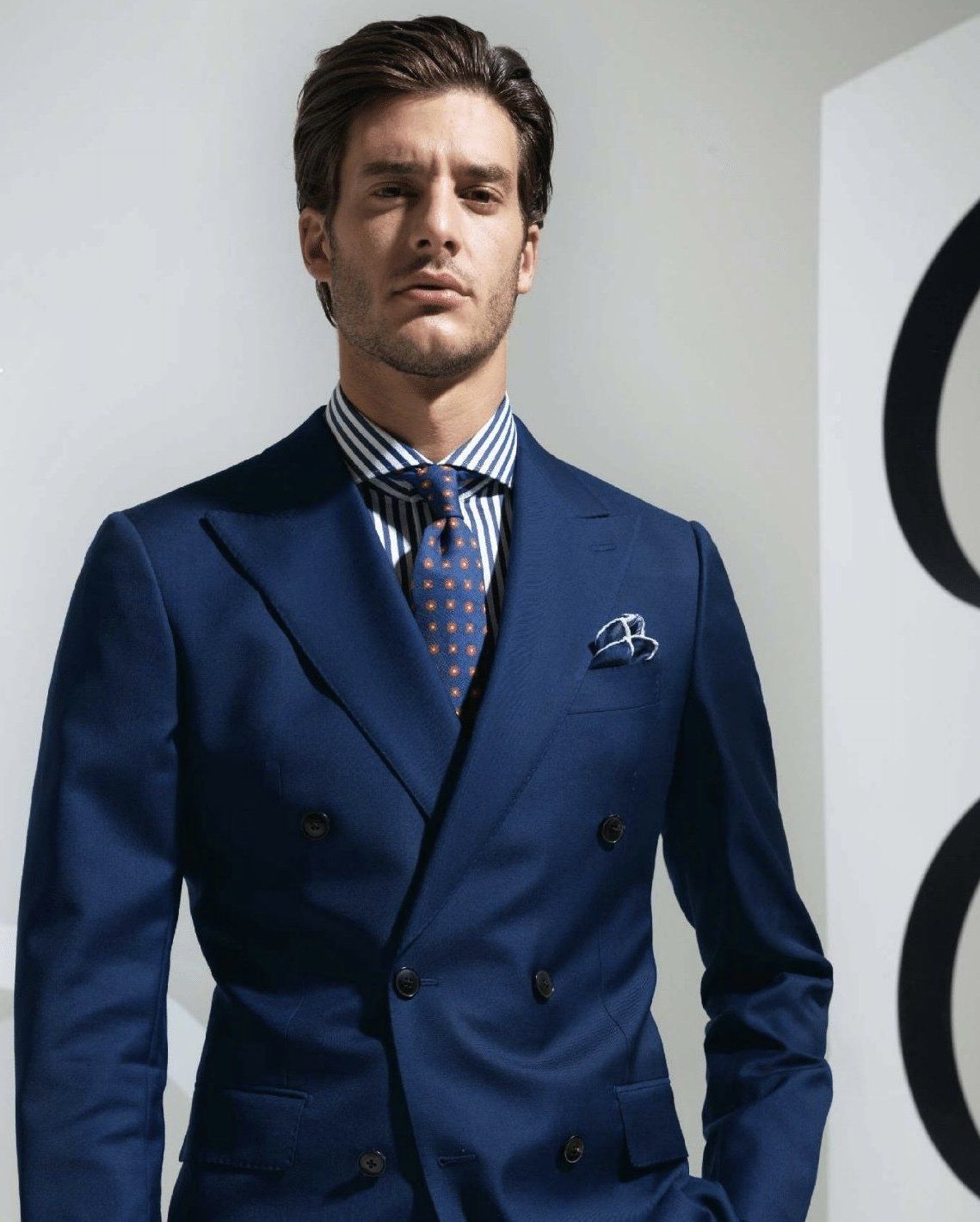 A man is wearing a blue suit and tie