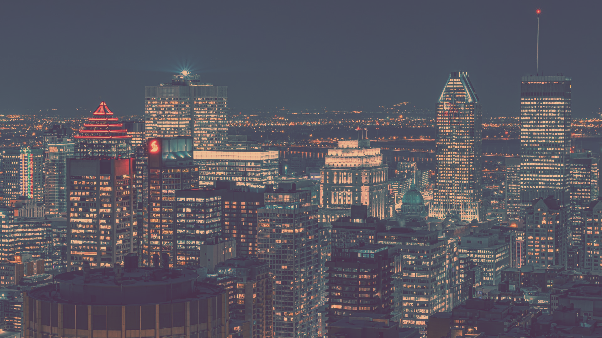 An aerial view of a city at night with lots of buildings lit up.