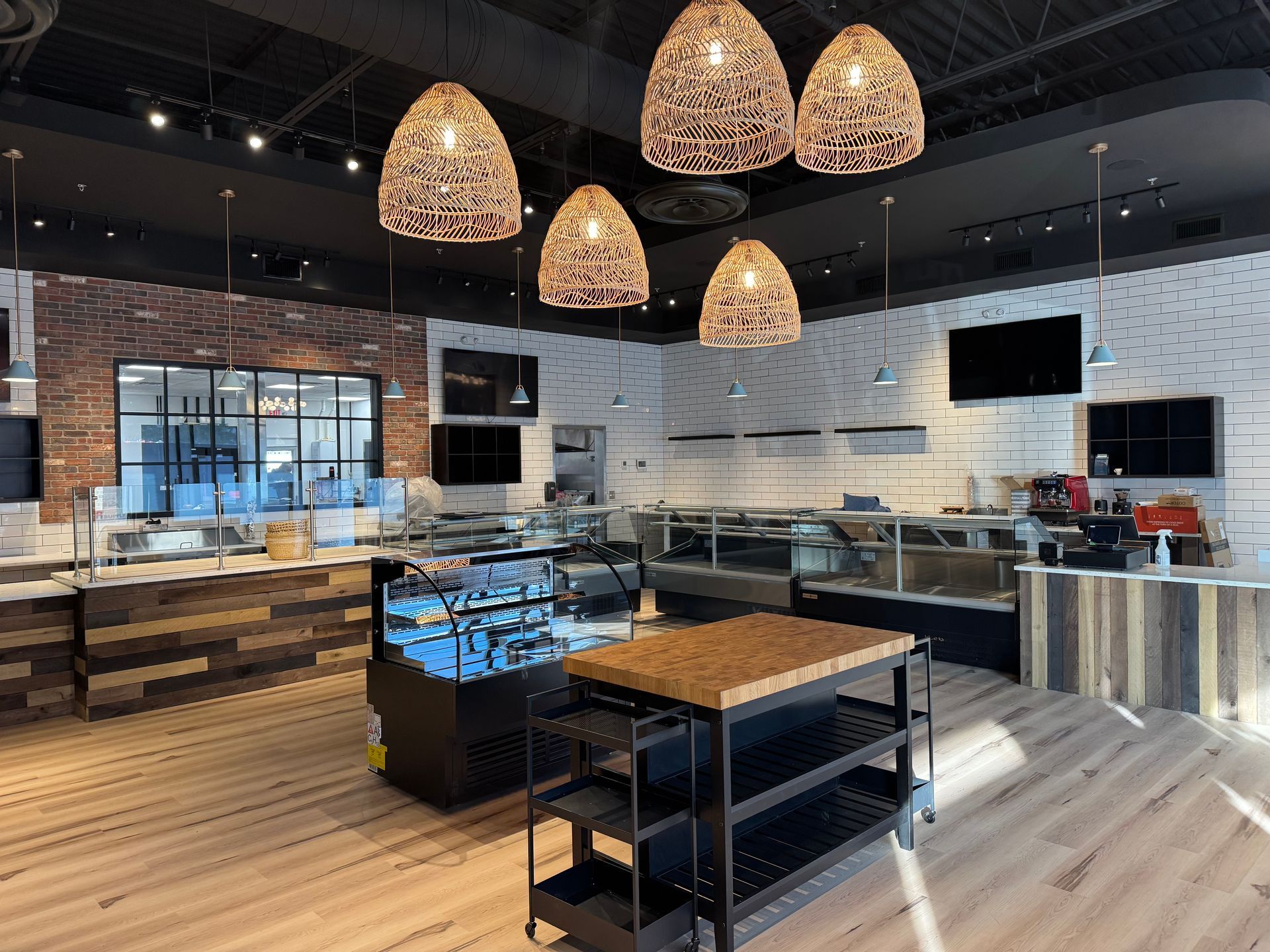 Commercial restaurant interior featuring woven pendant lights and illuminated display counters