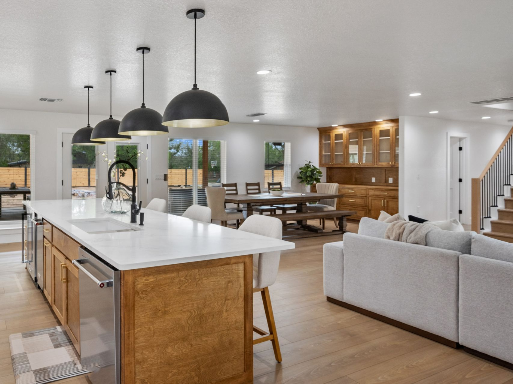Modern kitchen and living area with pendant lights and recessed ceiling lighting
