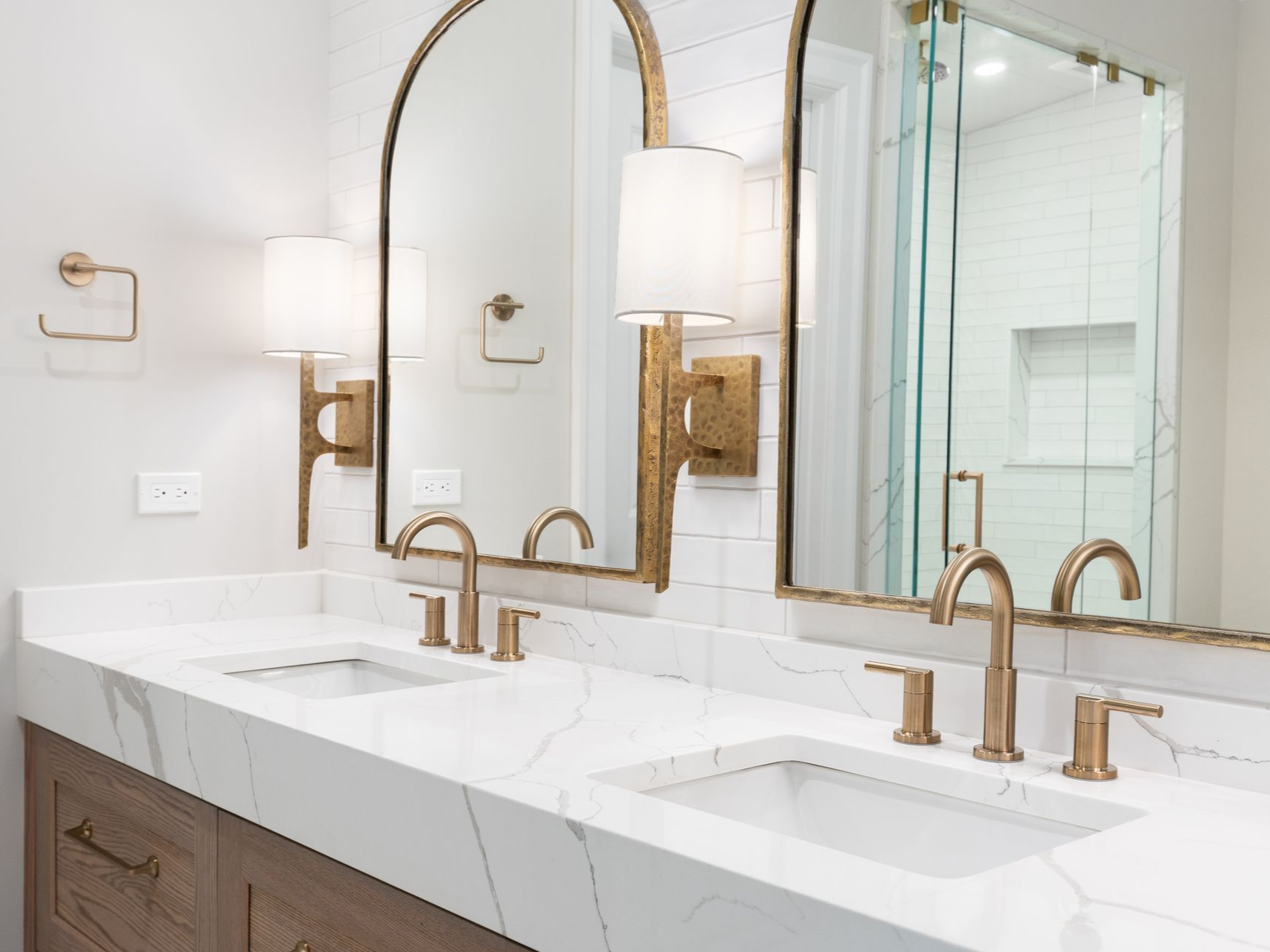 Modern bathroom renovation featuring wall-mounted vanity lights and electrical outlets