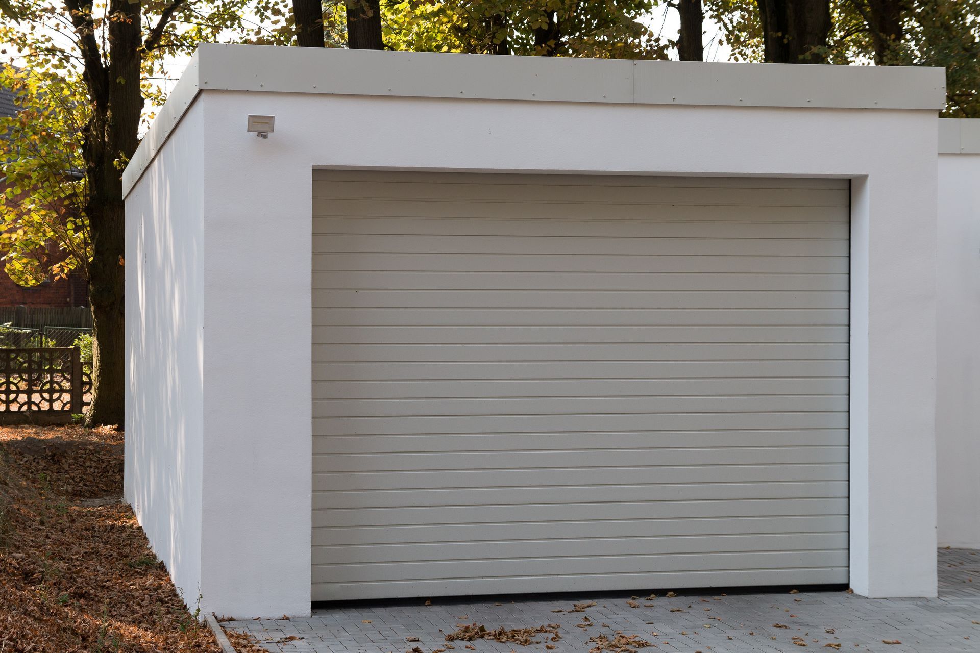 A modern new white garage with a roller shutter.