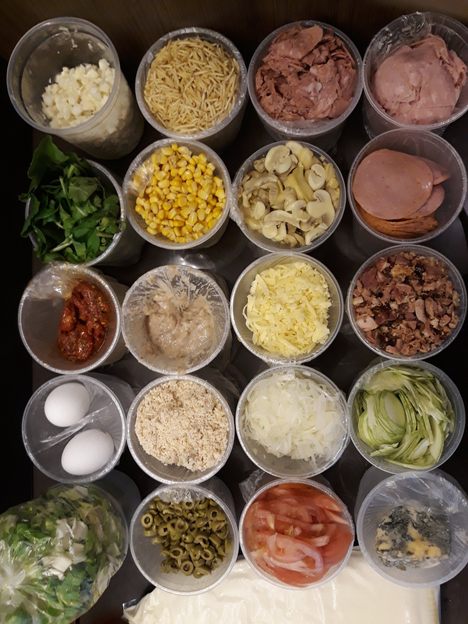 Ingredientes e condimentos variados dispostos em pequenas tigelas sobre a bancada, prontos para o preparo das refeições.