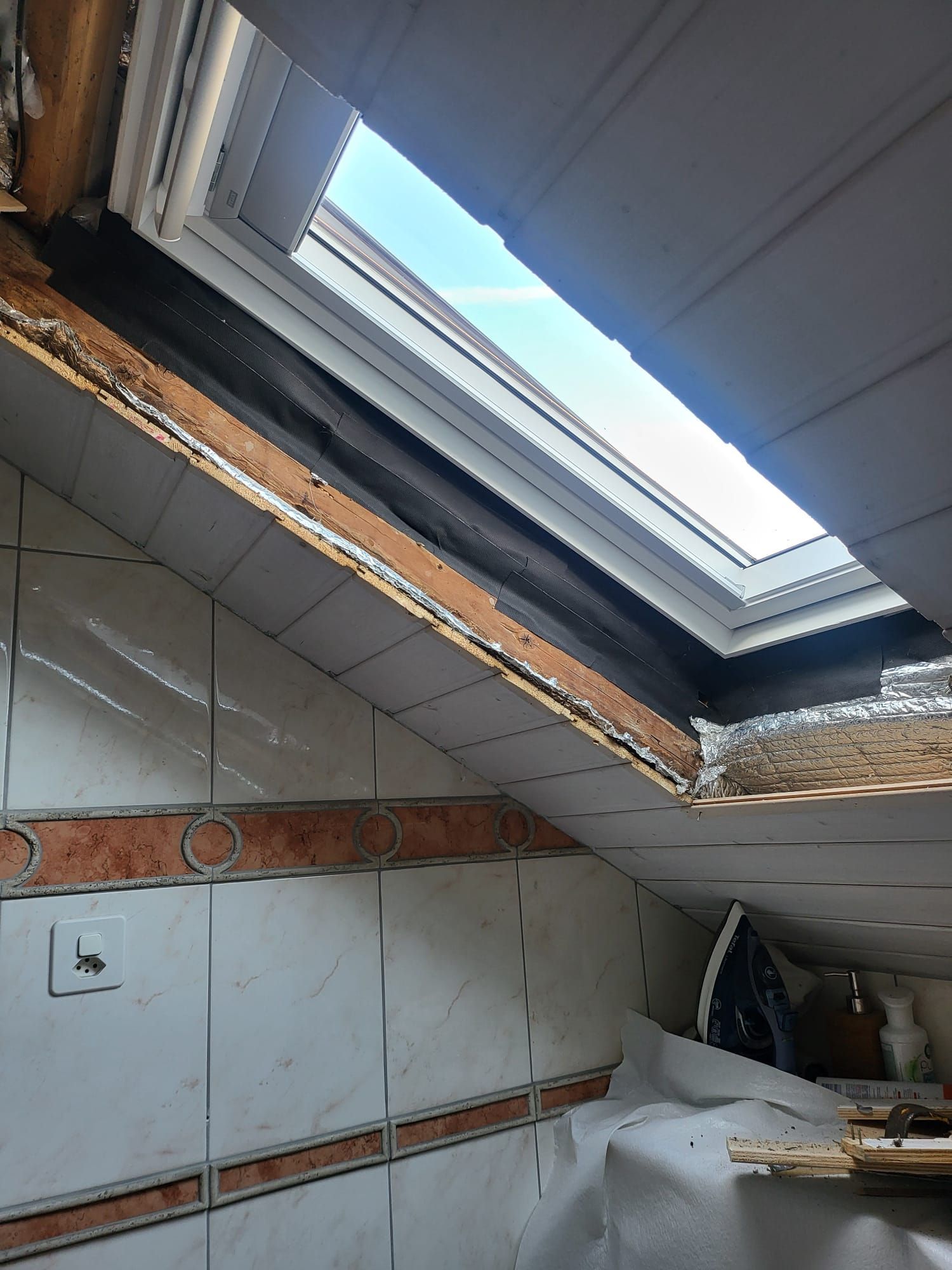 Une salle de bain avec un puits de lumière au plafond.
