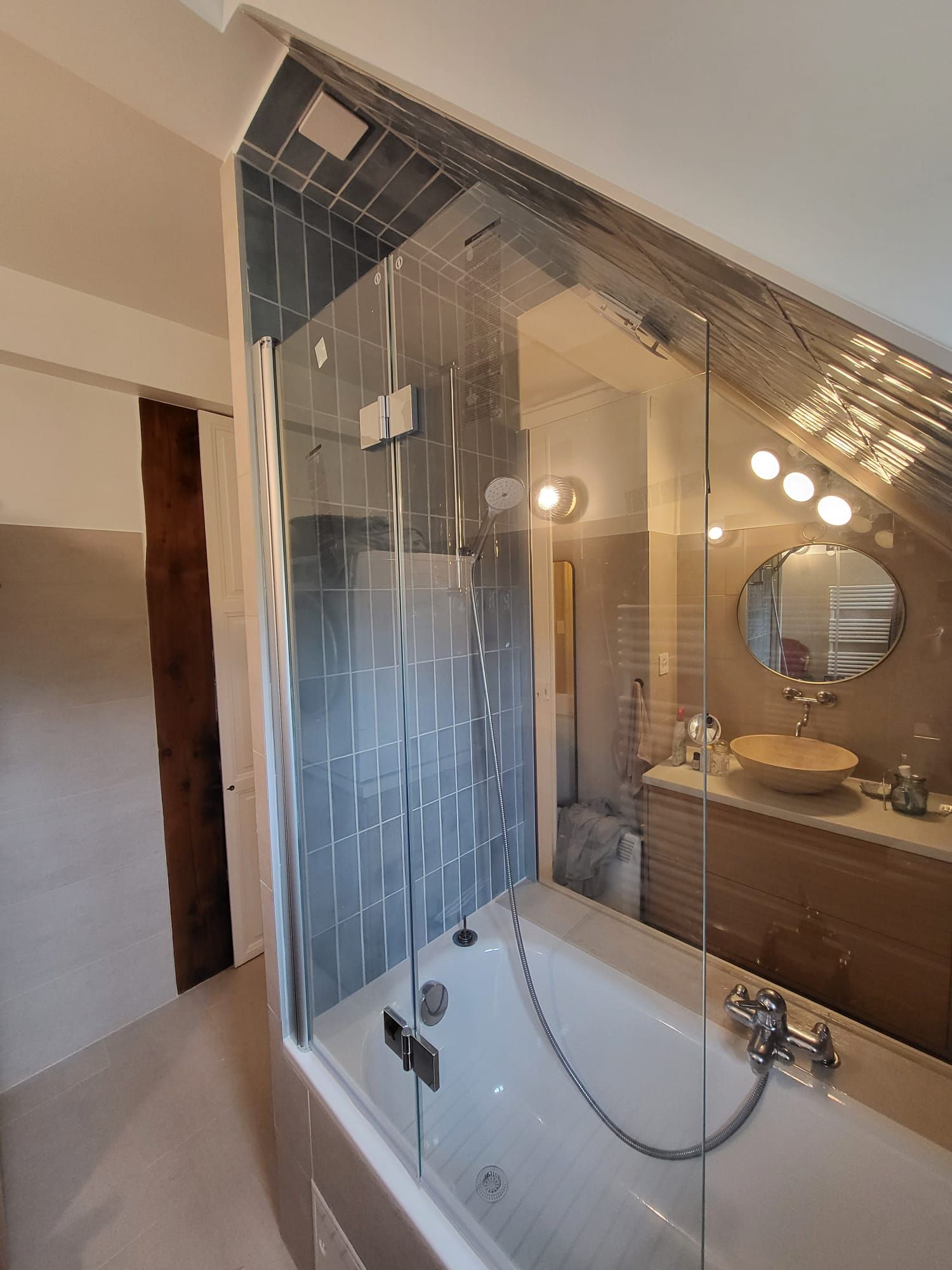 Une salle de bain avec baignoire, lavabo, miroir et douche.