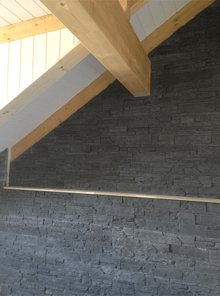 Une pièce avec un mur de briques et des poutres en bois au plafond.