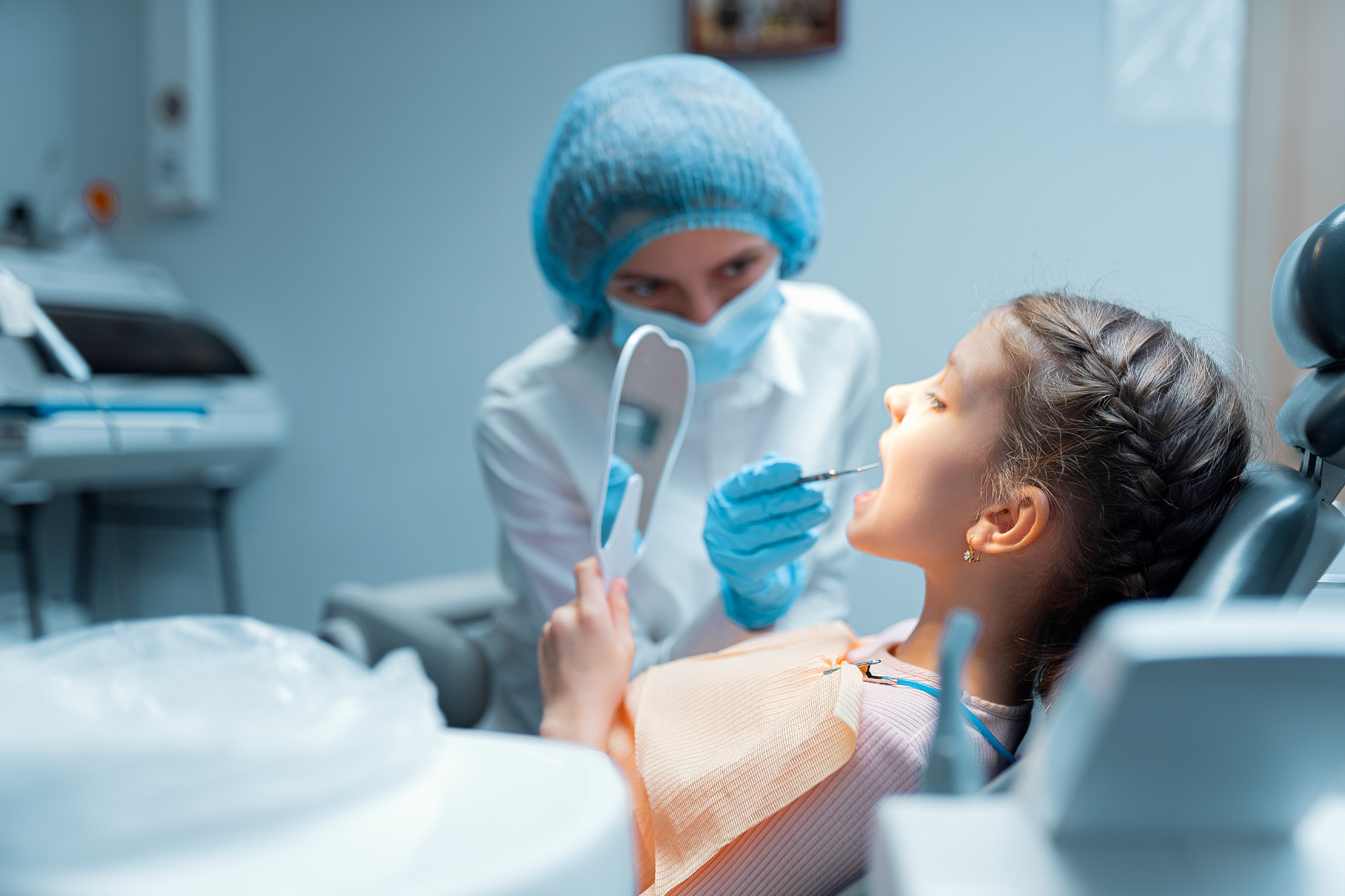 Dentista examinando la boca de un paciente con un espejo en una clínica luminosa