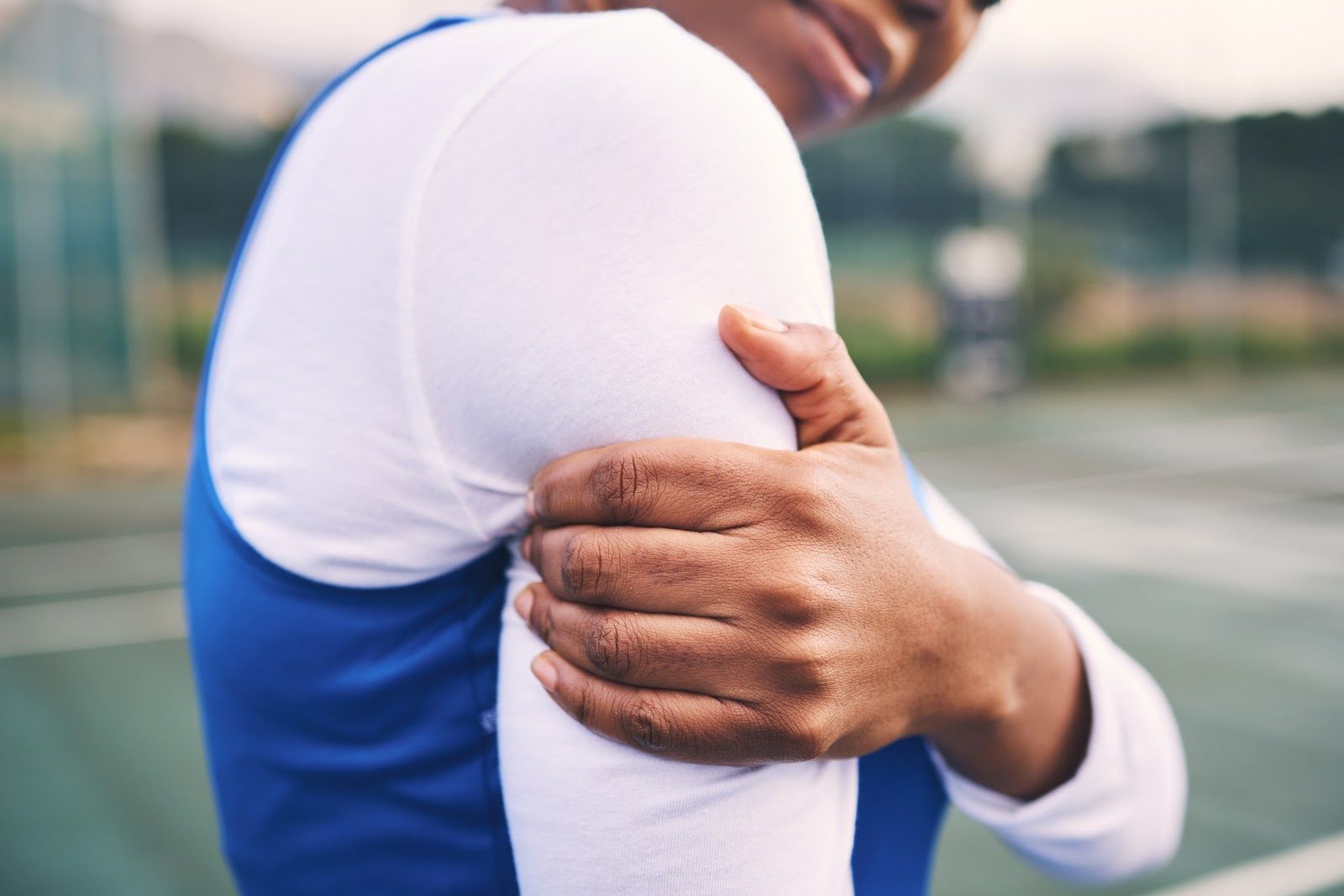 Hand resting on a person’s shoulder during an outdoor sports moment