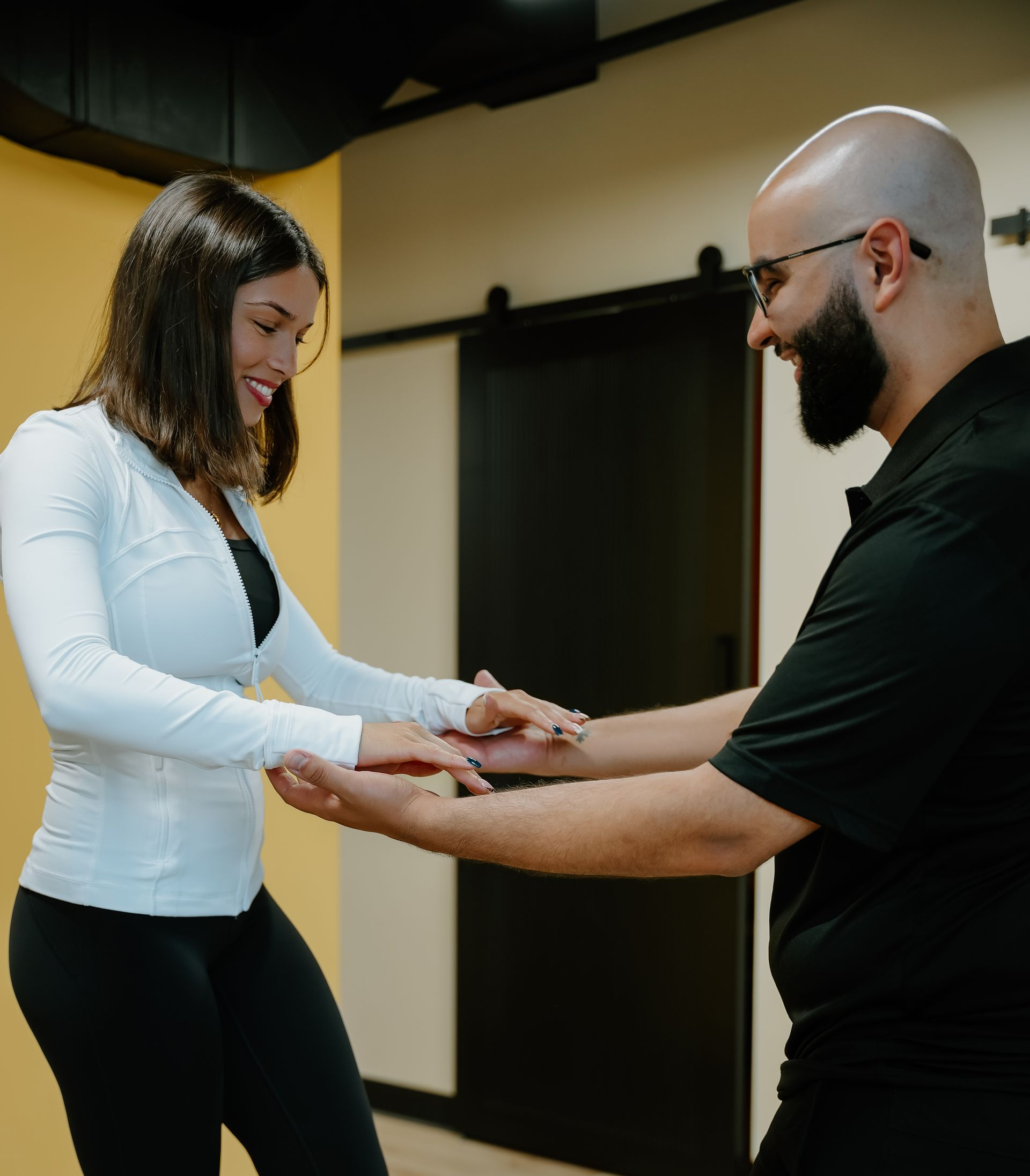 Two people holding hands in a calm indoor therapy or coaching session.