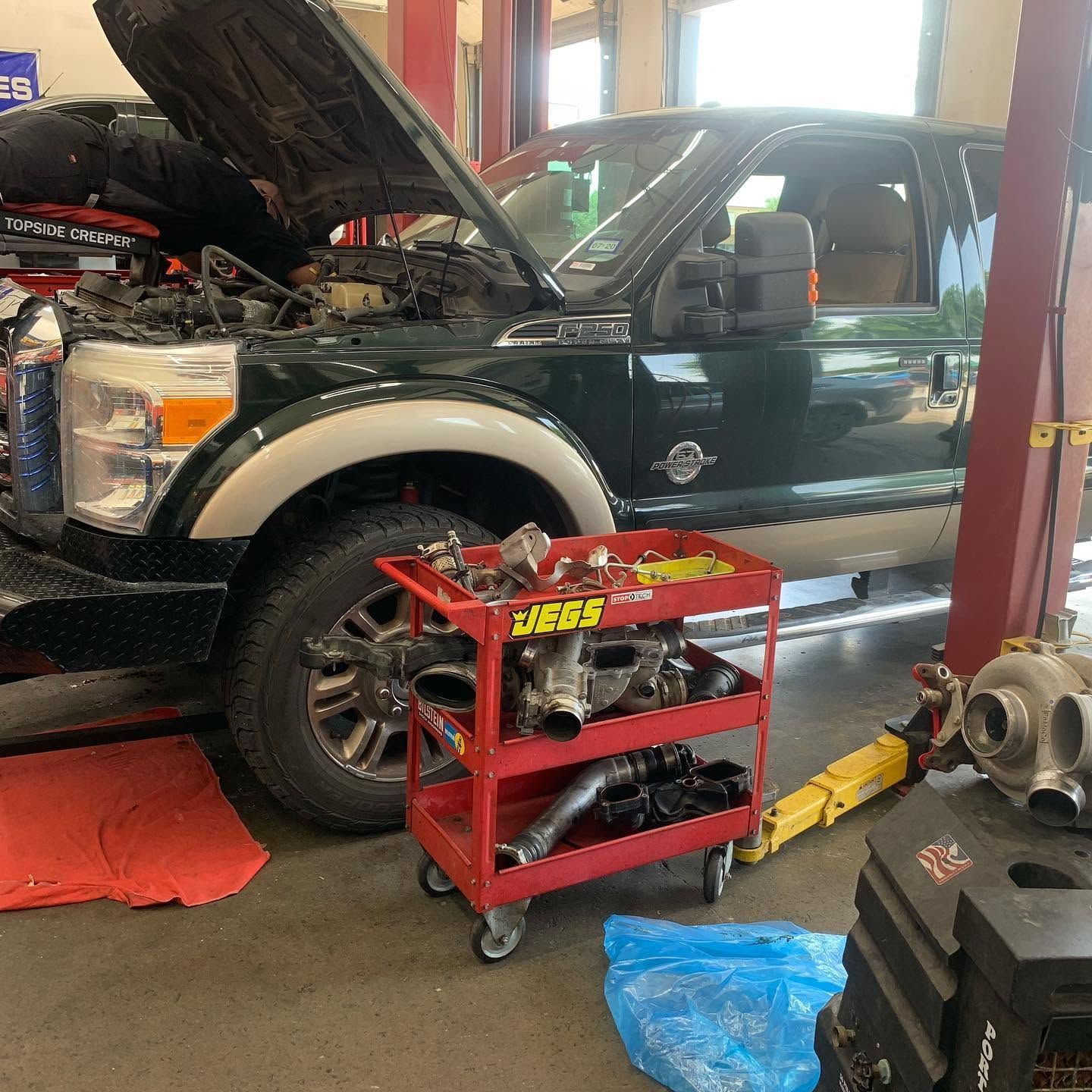 Black Pickup Truck With Hood Open And Wheel Removed For Repairs | CarDoc Automotive