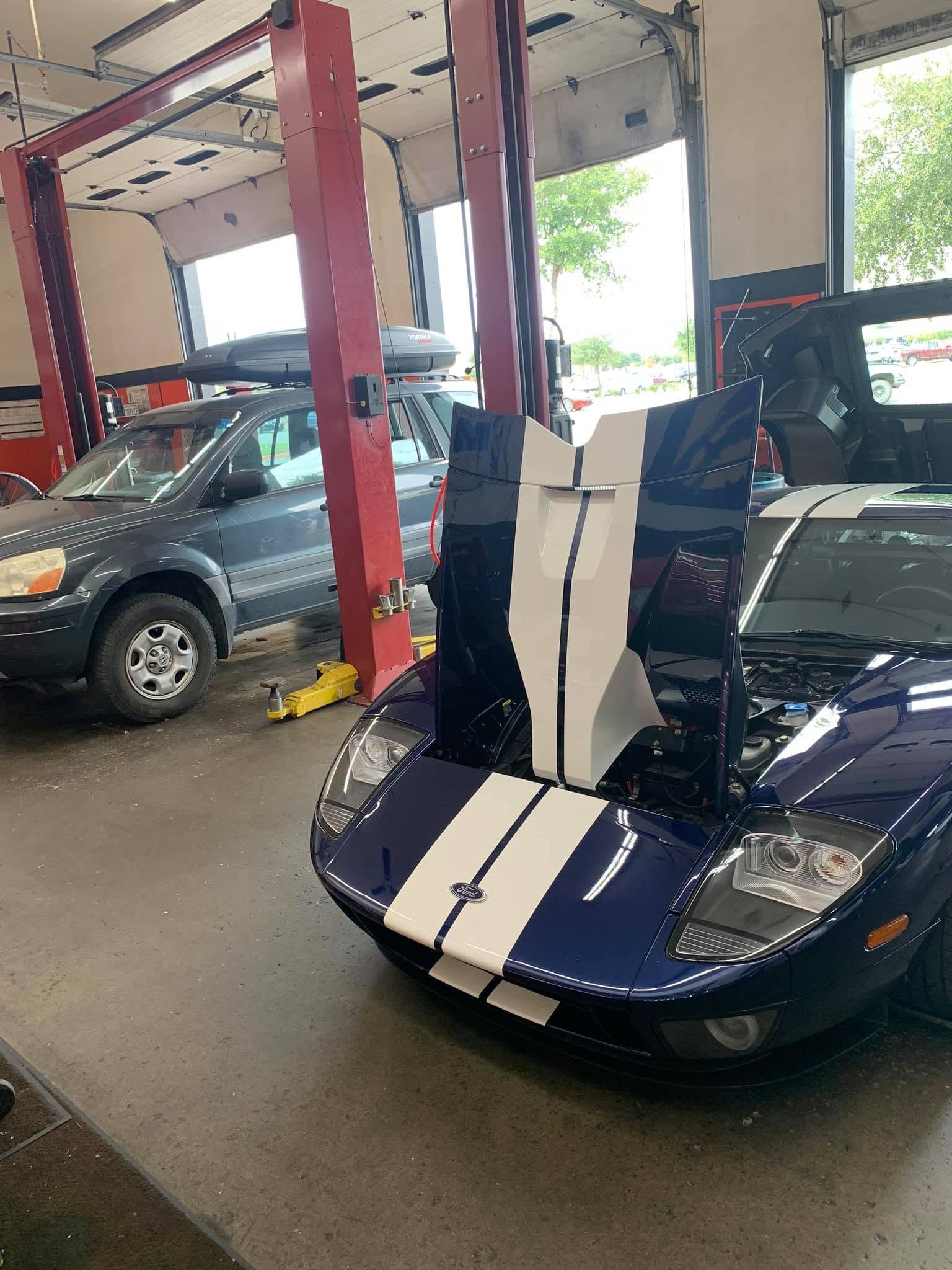 Blue And White Sports Car Parked Inside Automotive Service Bay | CarDoc Automotive