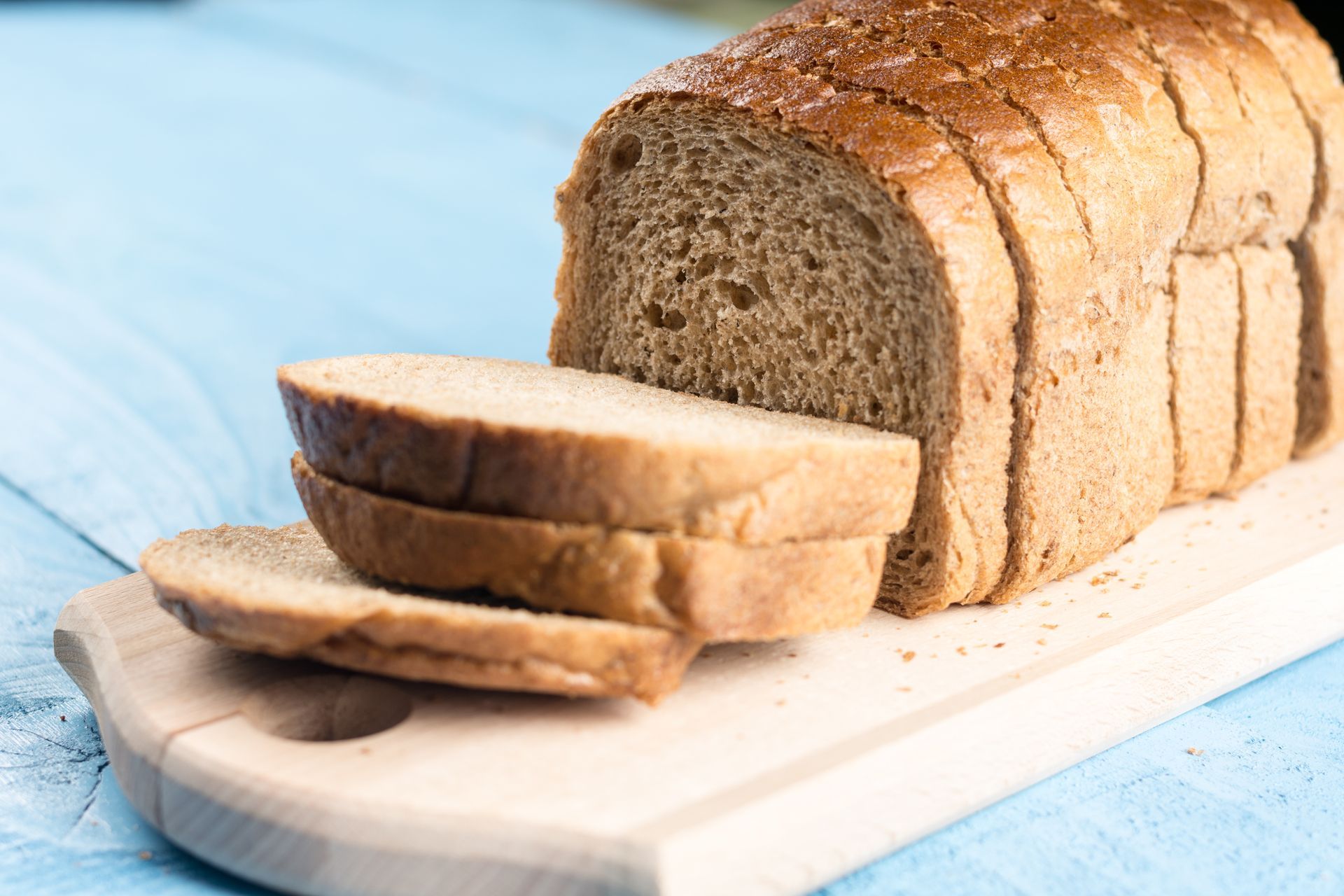 A loaf of bread is sitting on a wooden cutting board.