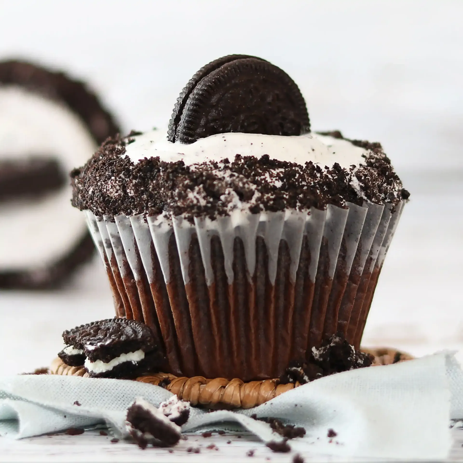 A wooden tray filled with chocolate and white frosted cupcakes.