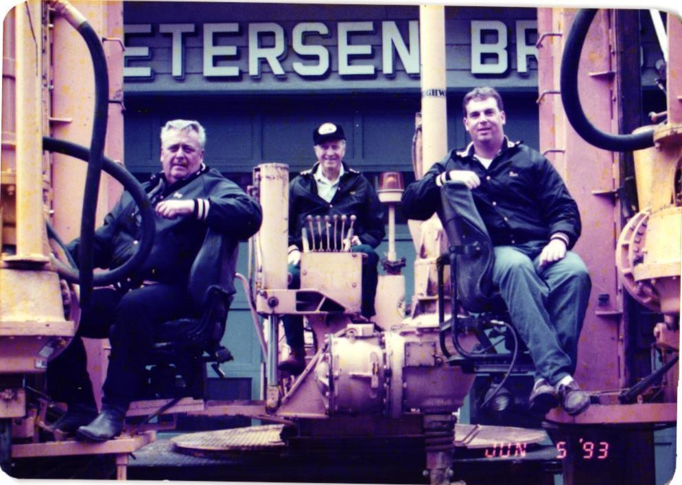 Three men on construction equipment; Petersen Bros. sign behind them, dated June 6 '93.