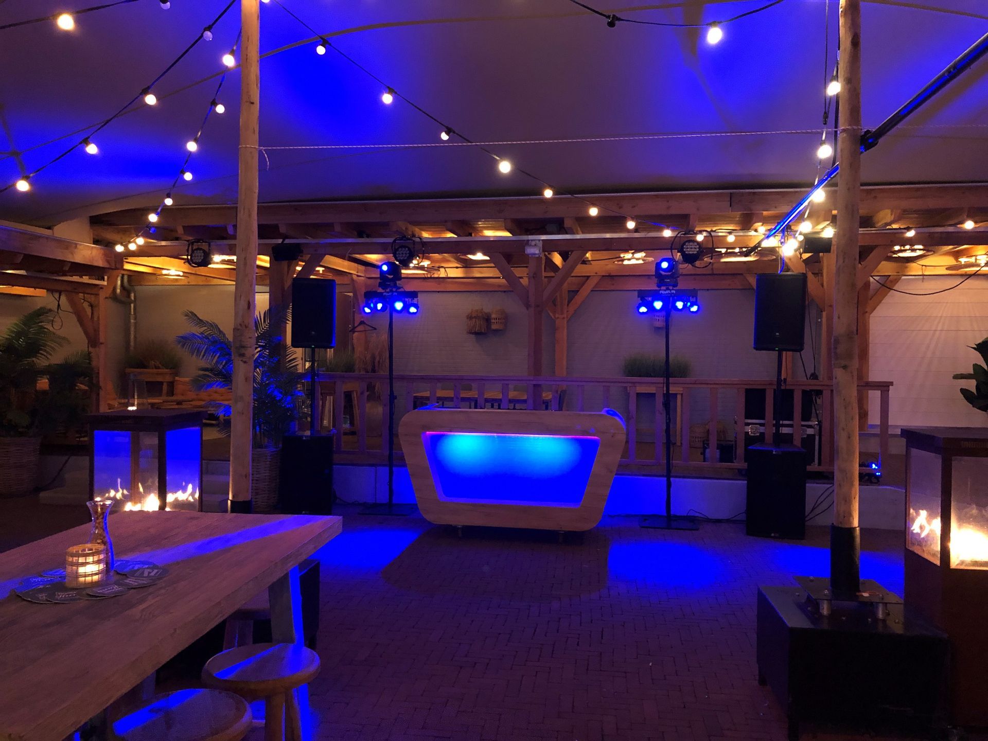 's Nachts is er een blauwverlichte lounge met tafels, krukken en een oplichtende bank onder een tentvormig plafond.
