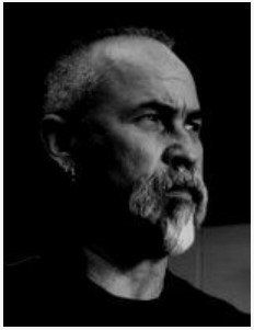 Black-and-white portrait of a bearded man in profile against a dark background