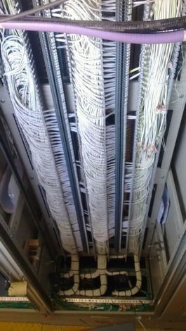 Bandejas portacables montadas en el techo con cables y tuberías agrupados en un espacio de servicios industriales.