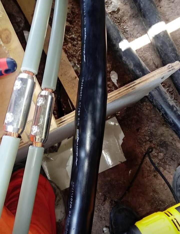 Primer plano de tuberías negras y tubos claros con conectores metálicos en un entorno de taller.