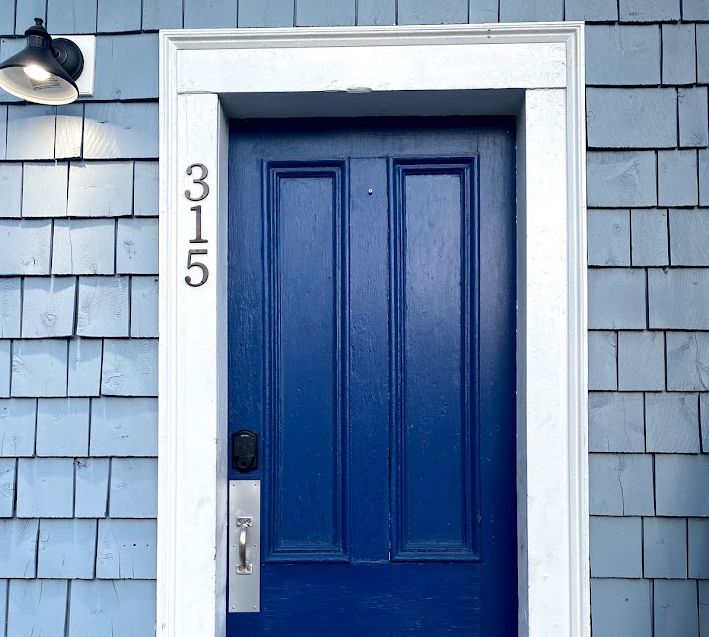 Blue door with address 315, white trim, and a black light fixture.